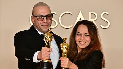 Iranian animators Hossein Molayemi and film Shirin Sohani pose with their Oscar statuettes after winning in the Best Animated Short Film category for their film In the Shadow of the Cypress. AFP