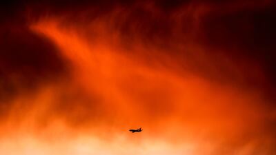A Virgin Australia Airlines Boeing 737 plane flies past storm clouds as it comes in to land at Sydney International Airport during sunset in Sydney. AFP