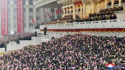 People wave the national flags as North Korean leader Kim Jong-un, centre top, attends a military parade, at Kim Il-sung Square. KCNA / AP