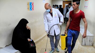 A member of the medical team sprays disinfectant in a dental clinic in Sadr city district of Baghdad, Iraq, March 9, 2020. Reuters