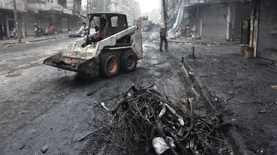 A tractor removes rubble in Aleppo's Shaar district as the Syrian government starts to clean up areas formerly held by opposition forces in the northern city on December 27, 2016. George Ourfalian/AFP