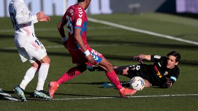 Elche's Johan Mojica passes the ball to Elche's goalkeeper Paulo Gazzaniga next to Real Madrid's Lucas Vazquez. AP