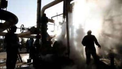 Iranian workers make repairs to a unit at Tehran's oil refinery. An Iranian oil ministry official said the country would scrap a number of LNG projects and focus on exporting gas by pipeline instead.