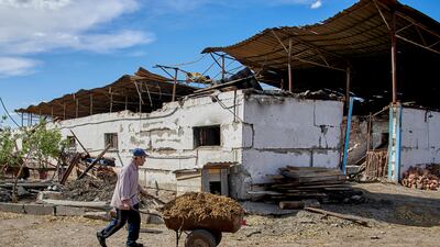 A man works on a damaged farm in the village of Mala Rohan, near Kharkiv, Ukraine. EPA