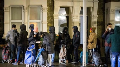 International students queue to collect food packages at the Newham Community Project food bank. AFP