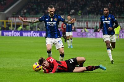 Inter Milan's Marcelo Brozovic protests his innocence as Brahim Diaz of AC Milan falls to the floor during the goalless Coppa Italia semi-final first leg on March 1, 2022. AFP
