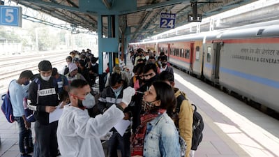 A health worker collects a swab sample from a traveller at a railway station to test for the coronavirus before allowing her to enter Mumbai, India. AP