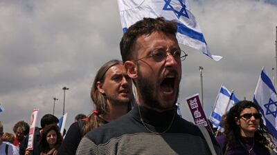 Protesters hold up Israeli flags and placards at the Knesset. AFP