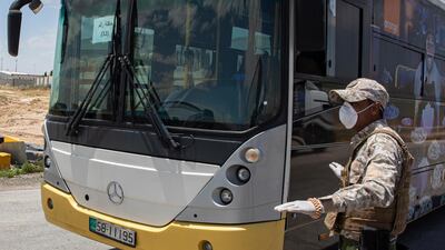 Members of Jordan's security forces check a bus that will transport returning Jordanian students from abroad. EPA