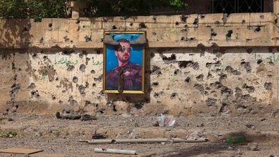 Shoes are hung over a picture of Bassel Al-Assad, brother of Syrian President Bashar Al-Assad, in the old airport neighbourhood in Deir al-Zor, Syria. Khalil Ashawi / Reuters