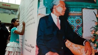 Monal Rasquinha, a student at Emirates Future International Academy in Abu Dhabi, signs the mural at Khalidiya Mall in honour of Nelson Mandela’s birthday.