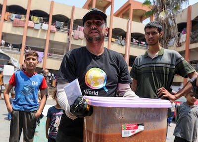 A World Central Kitchen team member prepares to serve meals to Palestinians after the charity resumed operations less than a month after seven aid workers were killed in Gaza by Israeli forces. Reuters