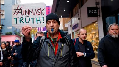 A protester holds up a placard as he takes part in an anti-lockdown protest against government restrictions designed to control or mitigate the spread of the novel coronavirus. AFP