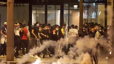 PSG fans try to avoid tear gas on the Champs-Elysees. Reuters