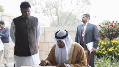Sheikh Mohammed bin Zayed signs a guest book during a visit to Raj Ghat. Mohamed Al Hammadi / Crown Prince Court - Abu Dhabi