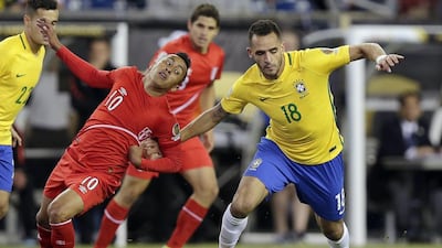 Peru’s Christian Cueva, left, and Brazil’s Renato Augusto fight for position. Charles Krupa / AP Photo