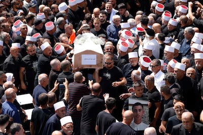 Mourners carry the coffin of a person killed in a rocket strike from Lebanon, during a mass funeral in Majdal Shams in the occupied Golan Heights on Sunday. AFP