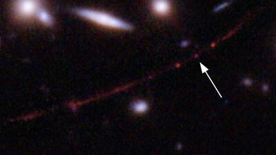 A Nasa image shows the star Earendel, indicated by arrow, and the Sunrise Arc galaxy, stretching from lower left to upper right. Nasa via AP