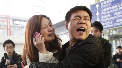 A relative (woman in white) of a passenger onboard Malaysia Airlines flight MH370 cries as she talks on her mobile phone at the Beijing Capital International Airport. The Malaysia Airlines flight carrying 227 passengers and 12 crew lost contact with air traffic controllers early on Saturday en route from Kuala Lumpur to Beijing, the airline said in a statement. (Kim Kyung-Hoon / Reuters / March 8, 2014)