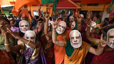 BJP supporters in Guwahati, Assam, wear masks of Indian Prime Minister Narendra Modi and dance as they celebrate the party's victory. AFP / Biju Boro