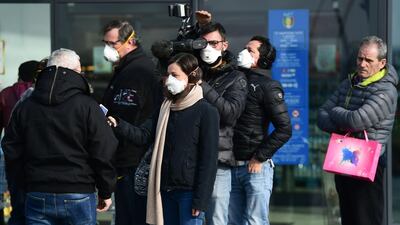 Reporters wearing respiratory mask interview a resident in the small Italian town of Casalpusterlengo, in the Lombardy region of Italy where all sporting events have been cancelled due to coronavirus fears. AFP