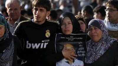 Palestinian relatives of Rushdi Tamimi, who died of injuries sustained in clashes with Israeli soldiers during a protest against Israel's strikes in Gaza, attend his Ramallah funeral.