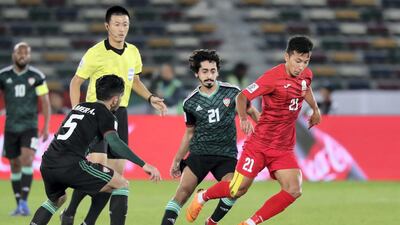 UAE's Khalfan Mubarak Al Shamsi, centre, tracks a Kyrgyzstan attack.