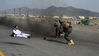 Taliban Badri special force fighters, right, and a journalist get up after they fell down from a vehicle at the airport in Kabul, after the US pulled all its troops out of the country. AFP