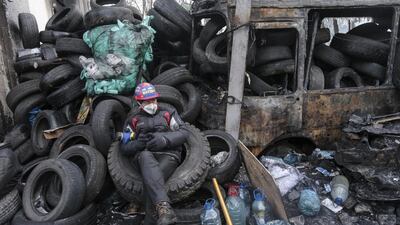 An anti-government protester rests near a barricade at the site of clashes with riot police in Kiev on January 26, 2014. Police clashed with protesters blockading a building in central Kiev on Sunday. The fate of Ukraine’s government was uncertain after embattled president Viktor Yanukovich offered opposition leaders key posts. Konstantin Chernichkin / Reuters