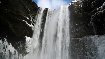 A man stands in front of the Skogafoss waterfall in Skogar, Iceland. Reuters