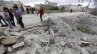 The violence continued in Syria on March 5, 2016 despite a partial truce still being in place. Residents inspect the damage after a bomb landed in the rebel-held town of Jarjanaz. Khalil Ashawi / Reuters