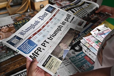 A man reads a Thai newspaper featuring front page coverage of Thailand's general election at a newsstand in Bangkok on Monday.