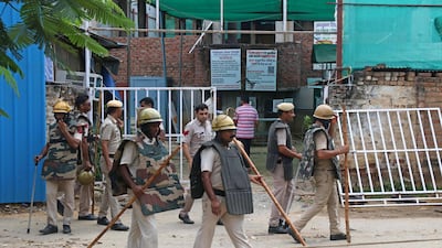Police officers stand guard outside a mosque after violent communal clashes in Gurugram, near New Dehli. AFP