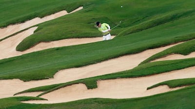 Chinese film director Feng Xiaogang plays a shot from a bunker during the final round of the Mission Hills World Celebrity Pro-Am golf tournament in Haikou, China. Tyrone Siu / Reuters