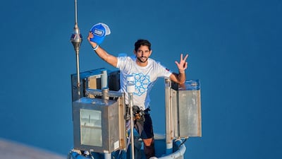 Dubai's Crown Prince Sheikh Hamdan, gestures as he wears a t-shirt bearing the logo of Dubai's 2020 World Expo campaign on top of Burj Khalifa, the world's tallest tower on November 25 to mark the emirates 42nd independence day and as part of a campaign that Dubai launched to win the World Expo 2020. AFP PHOTO/HO/ALI ISSA-PERSONAL PHOTOGRAPHER OF SHEIKH HAMDAN BIN MOHAMED BIN RASHID AL-MAKTOUM
