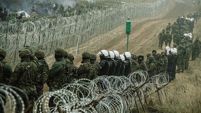 Polish soldiers, police forces and border guard officers at the border fence in Kuznica, eastern Poland. EPA
