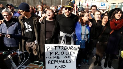 Protesters display signs and shout slogans as they march towards the Tree of Life synagogue. EPA