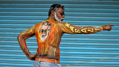A fan with his body painted with an image of actor Rajinikanth on his back poses outside a movie theatre showcasing Kabali in Bengaluru. Abhishek N Chinnappa / Reuters