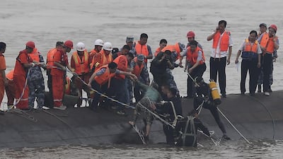 A survivor of an overturned passenger ship is rescued June 2, 2015, in the Jianli section of the Yangtze River in central China's Hubei province. The cruise ship went down overnight in a storm on the river, state broadcaster CCTV said. Cheng Min / Xinhua via AP