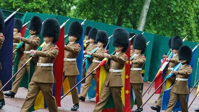 Troops carrying flags of Commonwealth nations march on The Mall. PA