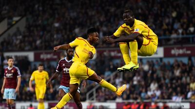 Raheem Sterling of Liverpool scores is team's first goal as teammate Mario Balotelli of Liverpool jumps to avoid the shot during their Premier League match on Saturday. Mike Hewitt / Getty Images