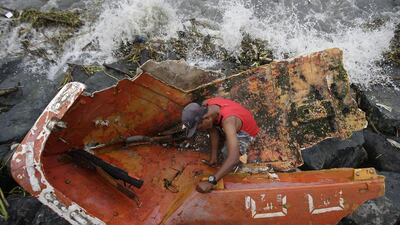 Filipino Joybin Marayo, 58, salvages metals on a damaged boat that was washed ashore by strong waves brought about by Typhoon Haima in Manila. Aaron Favila / AP Photo