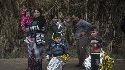 Refugees stand on a road after arriving at the northeastern Greek island of Lesbos by sea, on Wednesday, Dec. 16, 2015. Greek authorities say two people have drowned and 83 others have been rescued after a wooden boat crammed with refugees sank in the Aegean Sea off the eastern Greek island of Lesbos. (AP Photo/Santi Palacios)
