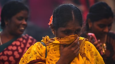 A woman covers her face on a crowded street in Chennai, India, on Tuesday, amid a spike in Covid-19 cases. EPA