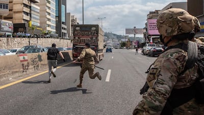 Lebanese army soldiers scuffle with supporters of Lebanese Christians parties where they try to open the Northern Highway during a protest against the collapsing Lebanese pound currency and the price hikes of goods, in Al-Zouk area, northern Beirut, Lebanon. EPA