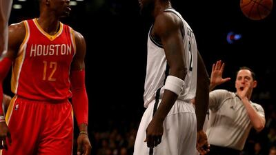 Dwight Howard, left, of the Houston Rockets, and Kevin Garnett, right, of the Brooklyn Nets, argue during Houston's win over Brooklyn in the NBA on Monday night. Elsa / Getty Images / AFP / January 12, 2015