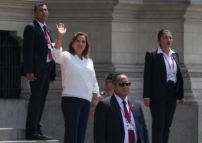 Surrounded by security, Peru's President Dina Boluarte waves to the press outside the government palace. AP Photo