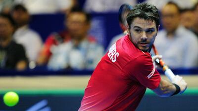 Stan Wawrinka of Singapore Slammers hits a return against Bernard Tomic of Indian Aces during their men's singles match at the IPTL on Saturday. Mohd Fyrol / AFP / December 19, 2015