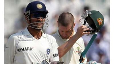 The India captain Mahendra Singh Dhoni, left, walks past Australia's Michael Clarke after defeating Australia on the fifth day of the second Test to take a 1-0 lead in the series.