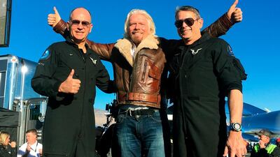 Richard Branson celebrates with pilots Rick “CJ” Sturckow, left, and Mark “Forger” Stucky, right, after Virgin Galactic’s tourism spaceship climbed more than 50 miles high. AP